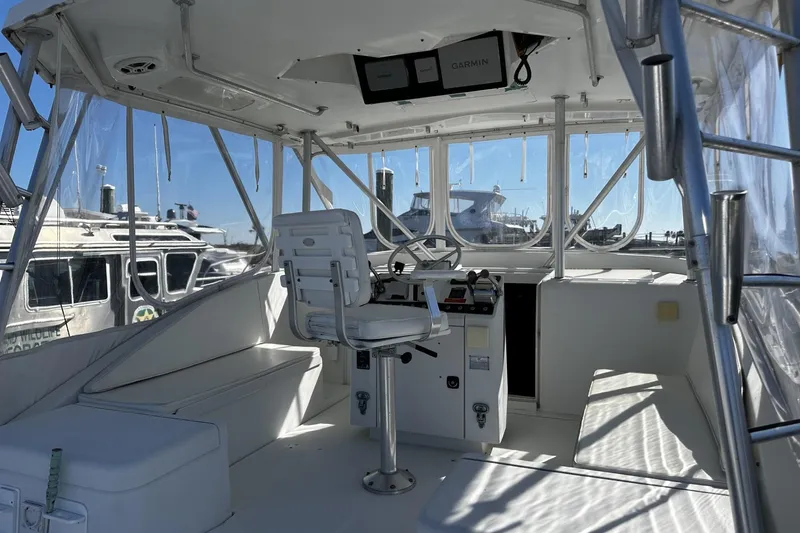 Slide: The Image of 1997 Luhrs 32 Open boat helm with seating, clear windows, and Garmin navigation system. - 10