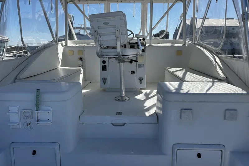 Slide: The Image of 1997 Luhrs 32 Open boat interior with helm and seating area, featuring clear enclosures. - 11