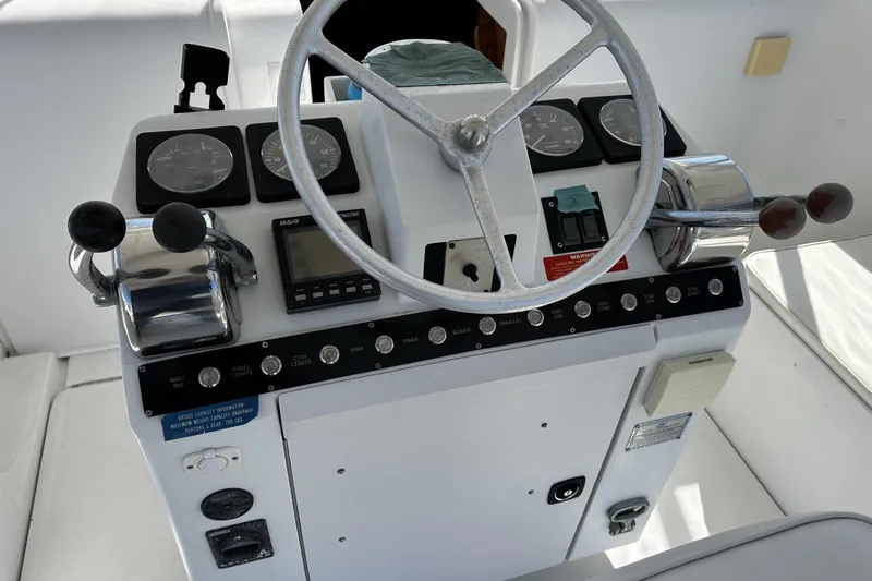 Slide: The Image of 1997 Luhrs 32 Open boat helm with steering wheel and control panel. - 14