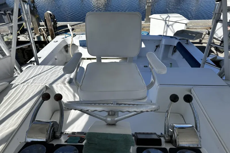 Slide: The Image of 1997 Luhrs 32 Open boat helm with white captain's chair and control panel. - 16