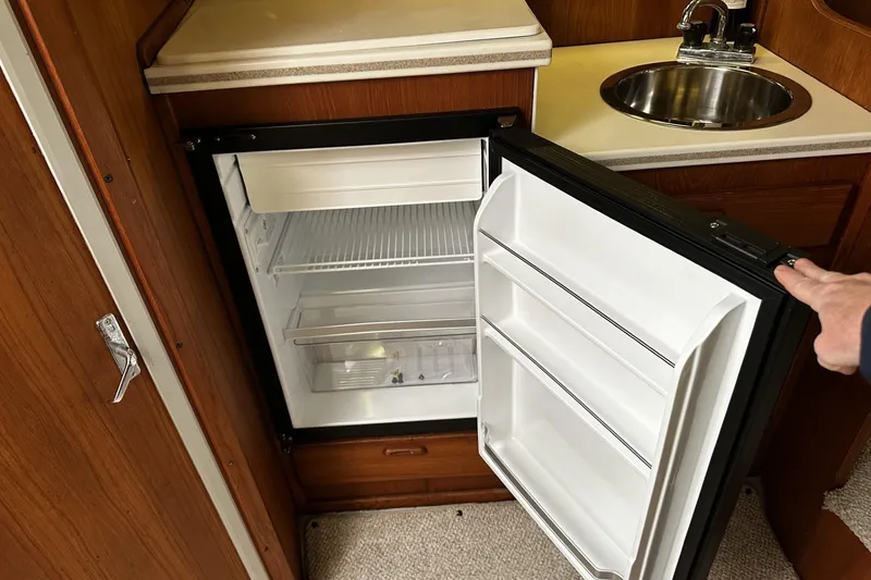 Slide: The Image of 1997 Luhrs 32 Open boat interior with open fridge and sink. - 23