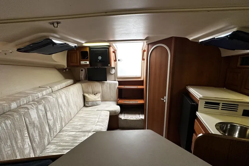 Slide: The Image of 1997 Luhrs 32 Open cabin interior with seating, kitchenette, and storage. - 25
