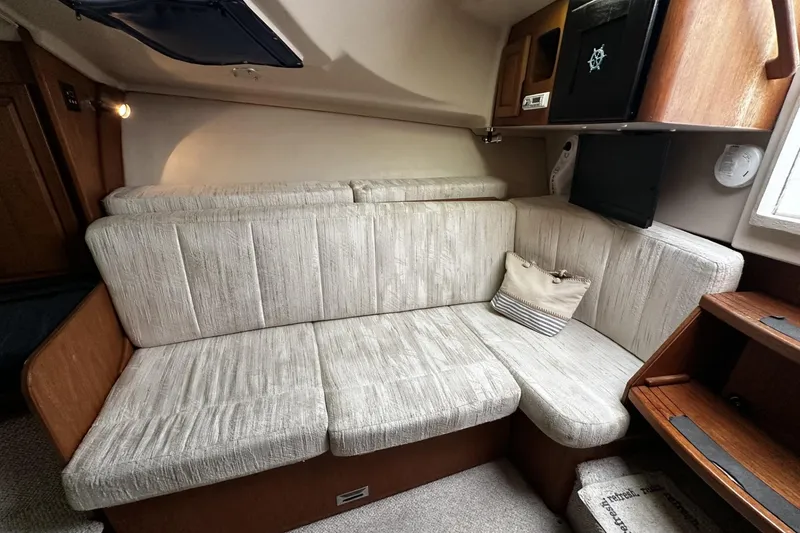 Slide: The Image of 1997 Luhrs 32 Open cabin interior with beige seating and wooden accents. - 26
