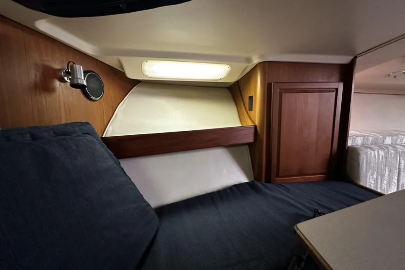 Slide: The Image of 1997 Luhrs 32 Open cabin interior with wood paneling and cozy seating area. - 29