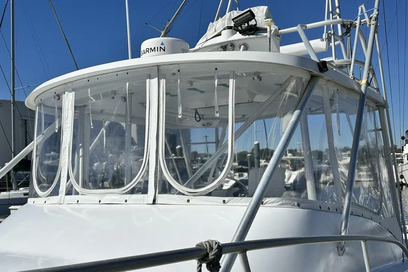 Slide: The Image of 1997 Luhrs 32 Open boat with clear enclosure and Garmin equipment, docked under blue sky. - 3