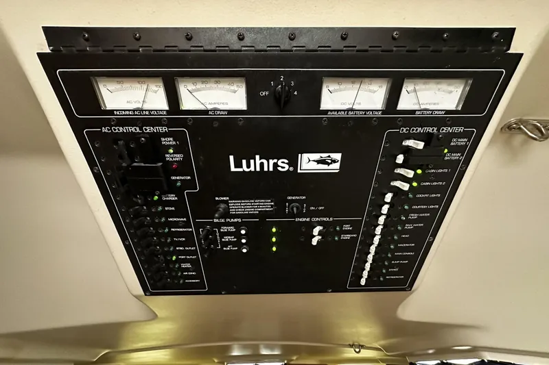 Slide: The Image of 1997 Luhrs 32 Open control panel with AC and DC systems, gauges, and switches. - 36