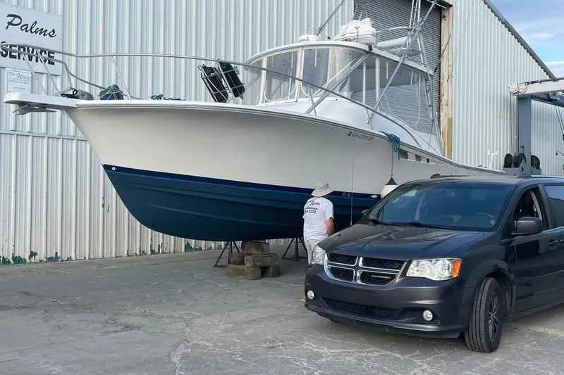 Slide: The Image of 1997 Luhrs 32 Open boat beside a black van at a service facility. - 56