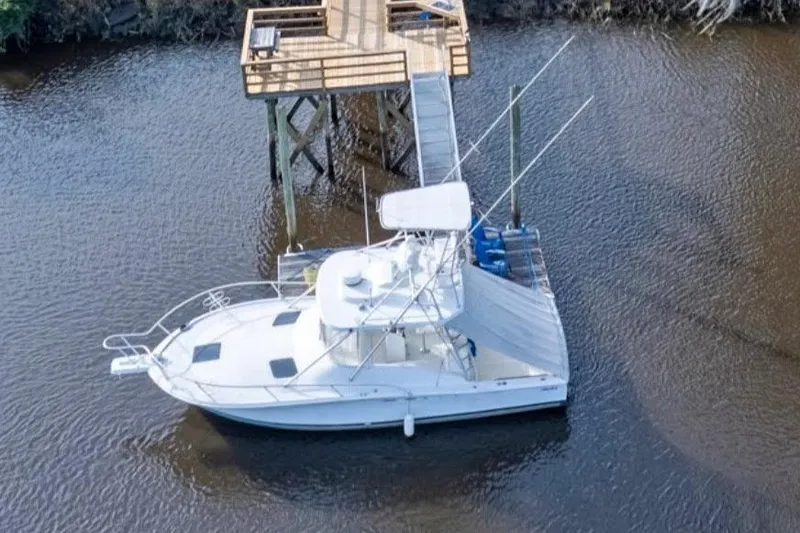 Slide: The Image of 1997 Luhrs 32 Open boat docked on calm water near a wooden pier. - 57