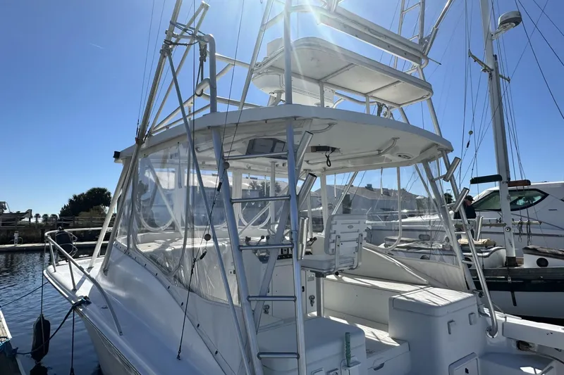 Slide: The Image of 1997 Luhrs 32 Open boat with tower, docked under clear blue sky. - 6