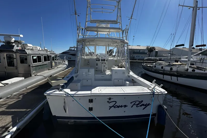 Slide: The Image of 1997 Luhrs 32 Open boat docked at marina, clear sky background. - 8