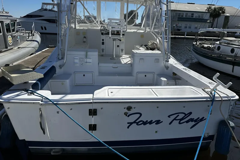 Slide: The Image of 1997 Luhrs 32 Open boat docked, featuring spacious deck and seating area. - 9