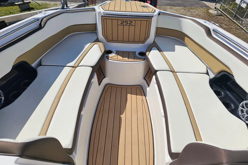 Slide: The Image of 2022 Yamaha Boats 252SD interior with luxurious seating and teak-style flooring. - 11