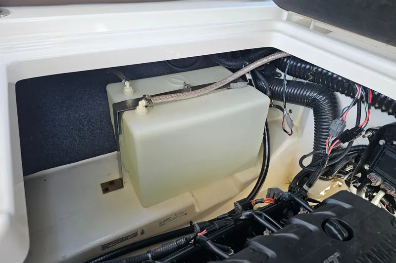 Slide: The Image of Engine compartment of 2022 Yamaha Boats 252SD, featuring wiring and fluid reservoir. - 25