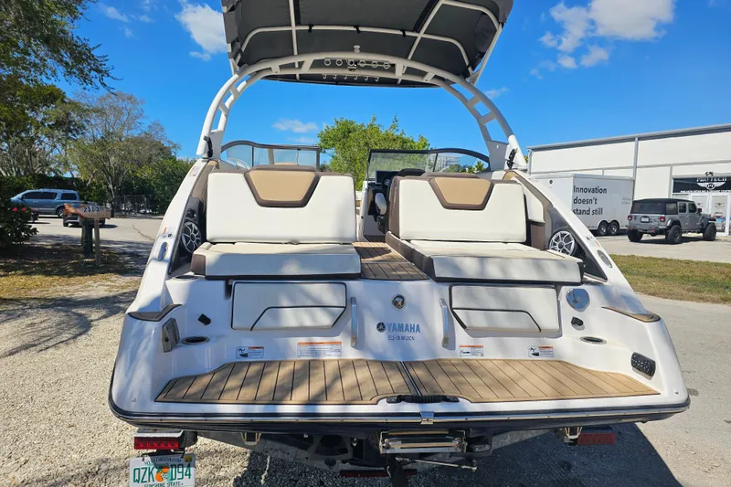 Slide: The Image of 2022 Yamaha Boats 252SD, rear view, showcasing seating and swim platform under a clear sky. - 4