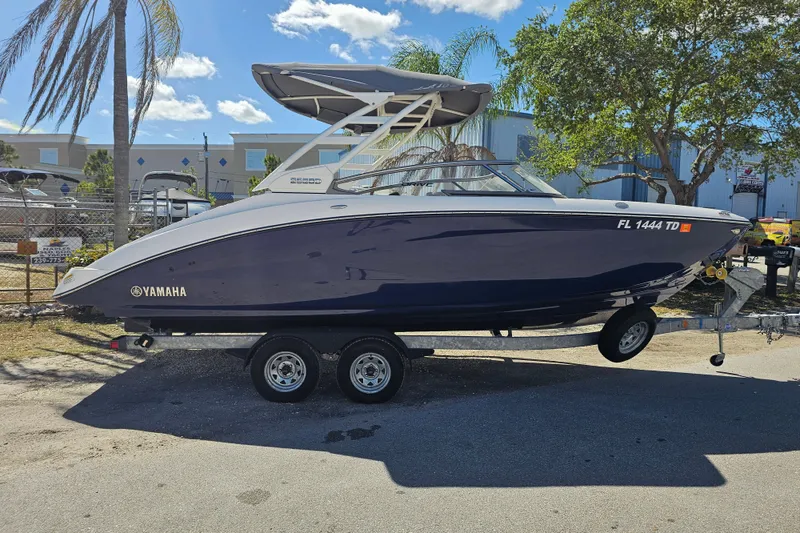 Slide: The Image of 2022 Yamaha Boats 252SD on trailer, parked outdoors under clear sky. - 7
