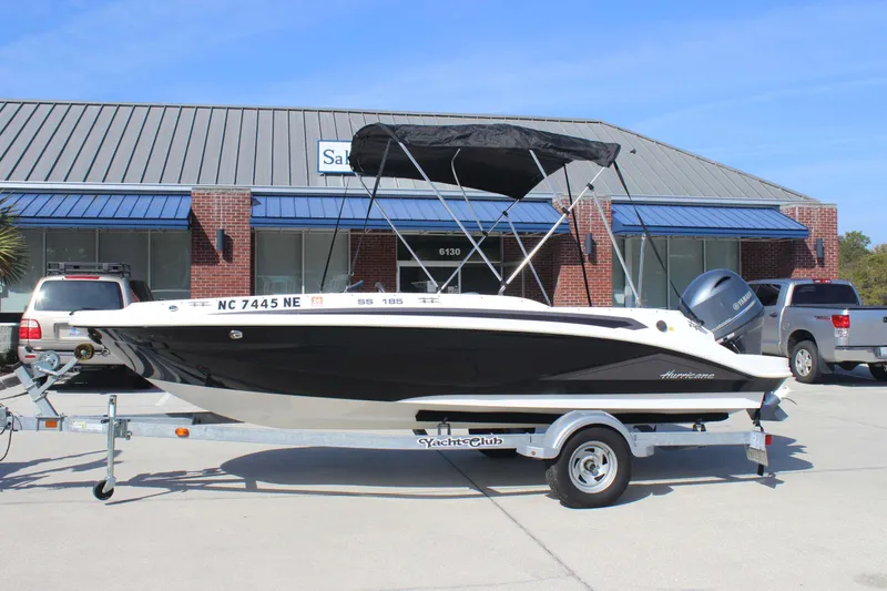 Slide: The Image of 2021 Hurricane SunDeck Sport 185 OB boat on trailer, parked outside a building. - 3