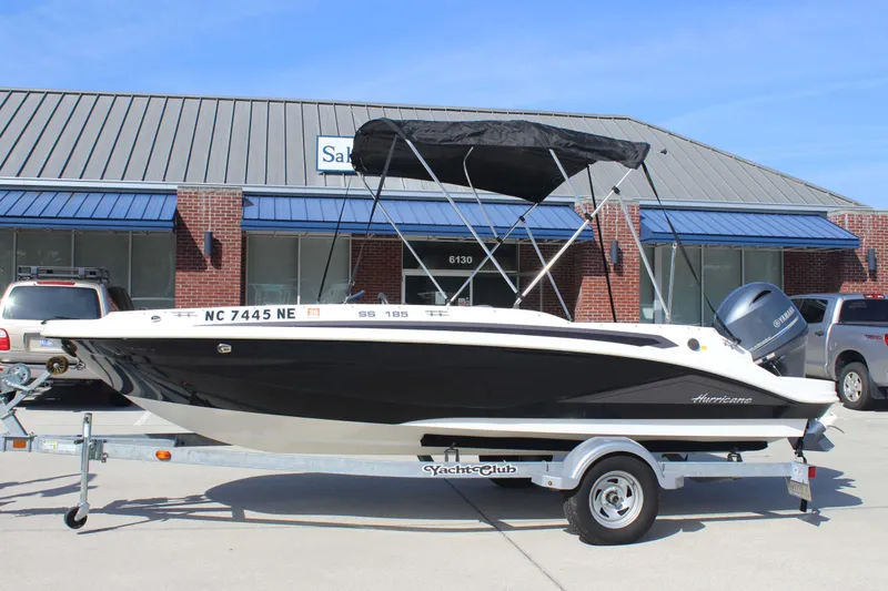 Slide: The Image of 2021 Hurricane SunDeck Sport 185 OB boat on trailer, parked outside a building. - 4