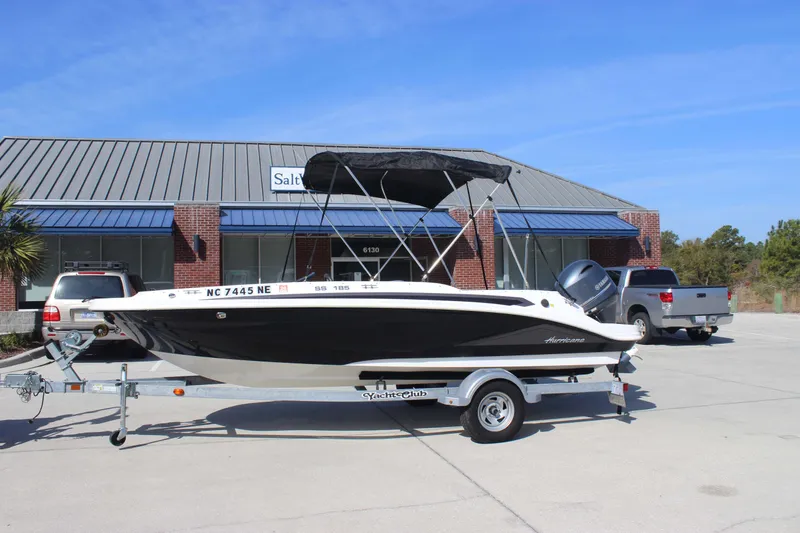 Slide: The Image of 2021 Hurricane SunDeck Sport 185 OB boat on trailer, parked outside a building. - 5