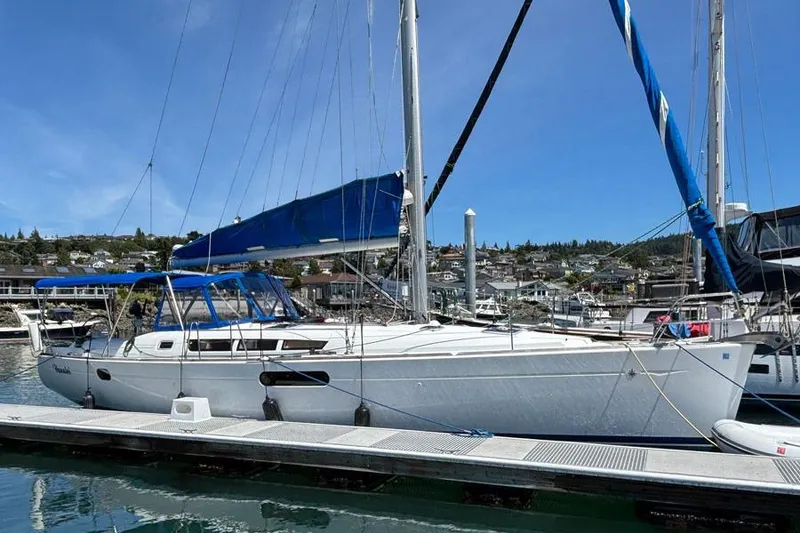 The Image of 2011 Jeanneau Sun Odyssey 44 sailboat docked at marina under clear blue sky. - 0