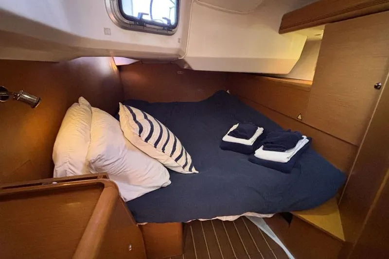 Slide: The Image of Cozy cabin interior of 2011 Jeanneau Sun Odyssey 44 sailboat with neatly arranged bedding. - 11