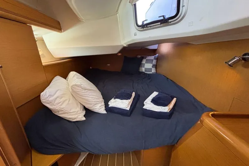 Slide: The Image of Cozy cabin interior of 2011 Jeanneau Sun Odyssey 44 sailboat with neatly arranged bedding. - 12