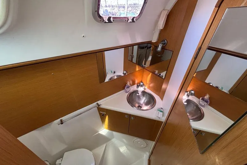 Slide: The Image of 2011 Jeanneau Sun Odyssey 44 bathroom with modern fixtures and wooden cabinetry. - 8