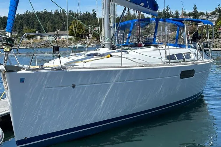 Slide: The Image of 2011 Jeanneau Sun Odyssey 44 sailboat docked in a scenic marina. - 1