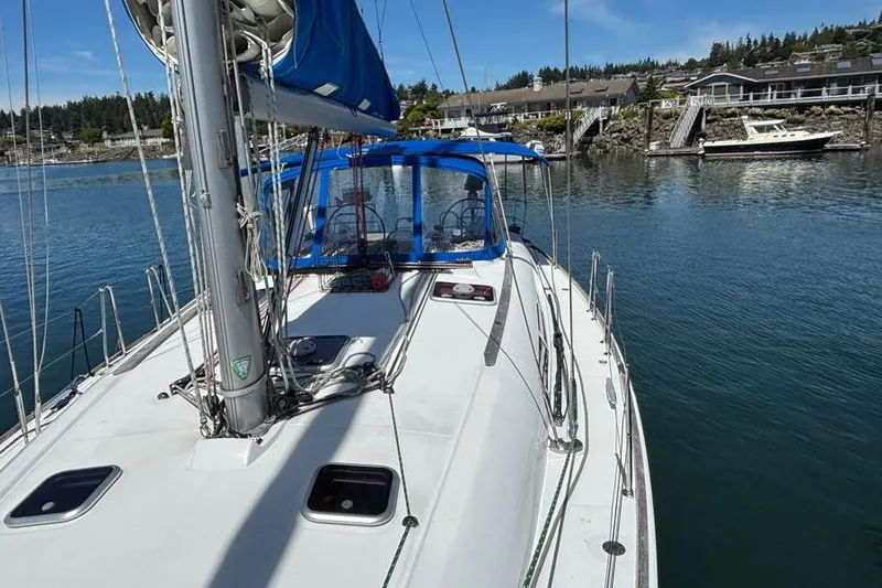 Slide: The Image of Jeanneau Sun Odyssey 44 sailboat, 2011 model, docked in a serene marina setting. - 5