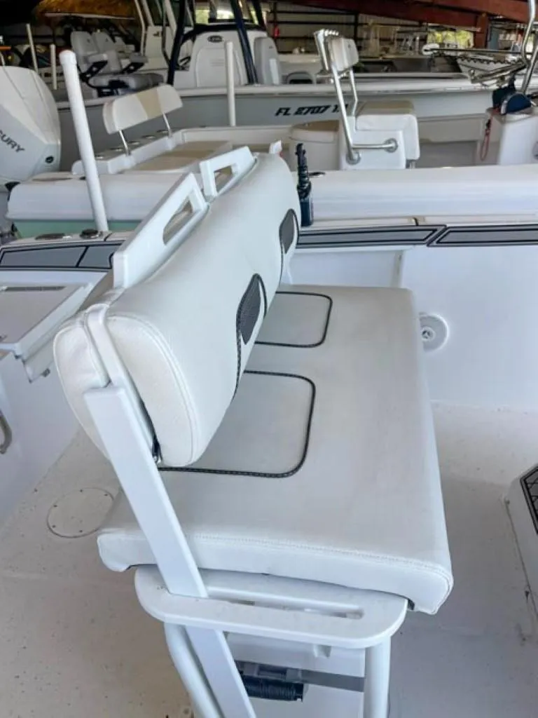 Slide: The Image of 2024 Wellcraft 202 Fisherman boat interior with white cushioned seating. - 10