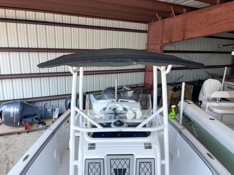 Slide: The Image of 2024 Wellcraft 202 Fisherman boat in storage, featuring a center console and T-top. - 14