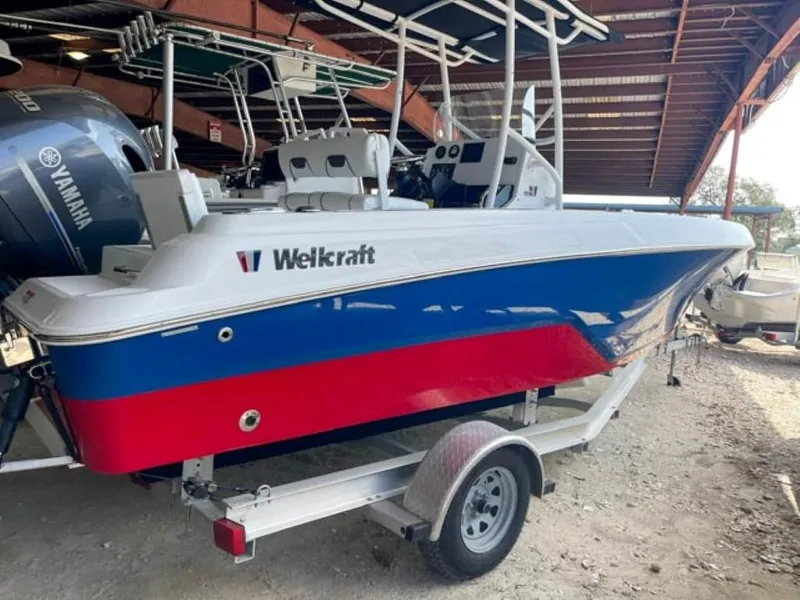 Slide: The Image of 2024 Wellcraft 202 Fisherman boat in red, blue, and white on a trailer. - 2