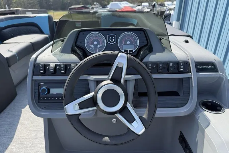 Slide: The Image of 2026 Godfrey Sweetwater 2286 SFL boat dashboard with steering wheel and control panel. - 24