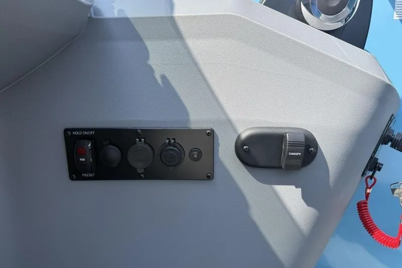 Slide: The Image of Control panel of 2026 Godfrey Sweetwater 2286 SFL boat with switches and canopy control. - 34