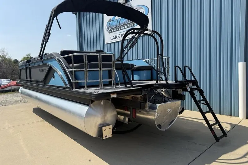 Slide: The Image of 2026 Godfrey Sweetwater 2286 SFL pontoon boat with canopy, parked outside marine center. - 5