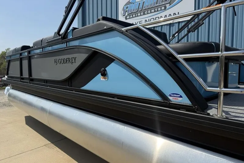 Slide: The Image of 2026 Godfrey Sweetwater 2286 SFL pontoon boat, blue and black design, docked at marina. - 6