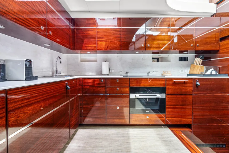 Slide: The Image of Luxurious yacht kitchen with glossy wood cabinets, modern appliances, and sleek design on Steeler 60S Performance. - 38
