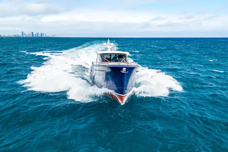 Slide: The Image of 2021 Steeler 60S Performance yacht cruising on open ocean with city skyline in background. - 7