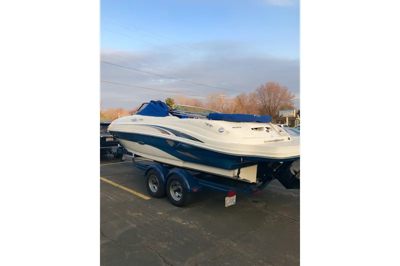 The Image of 2004 Sea Ray 220 Sundeck boat on trailer, parked outdoors. - 1