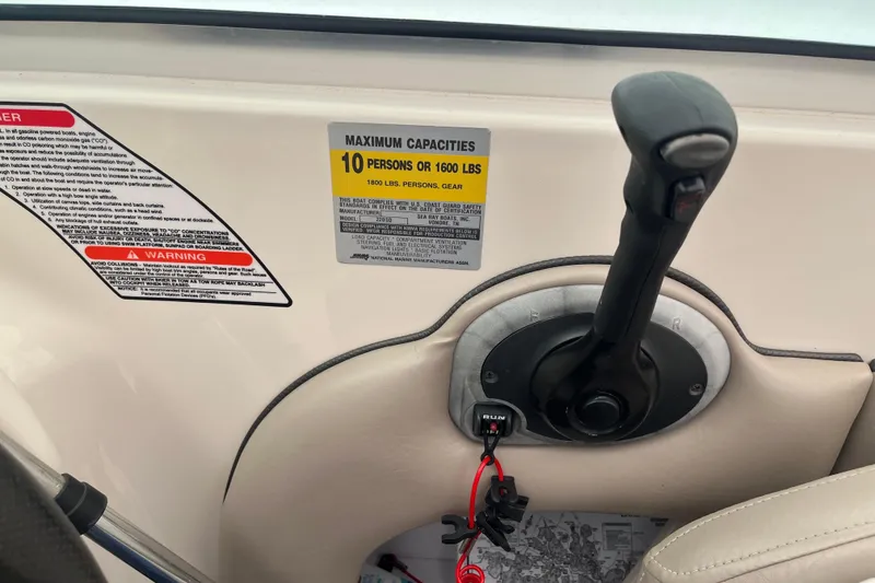 Slide: The Image of Control panel of 2004 Sea Ray 220 Sundeck with capacity warning label. - 14