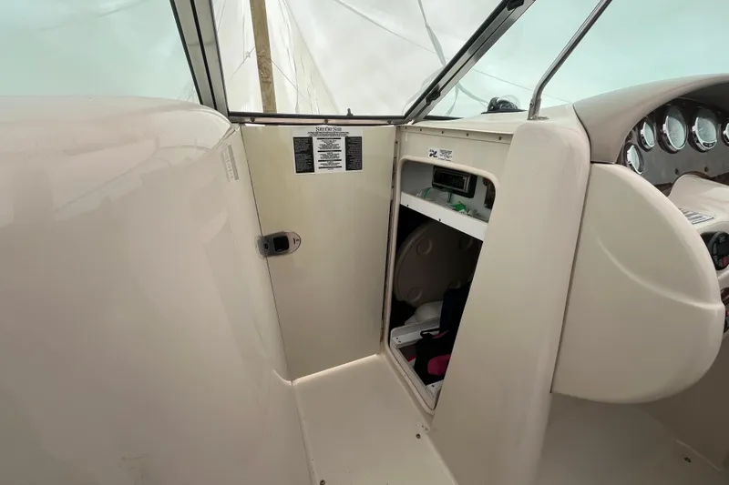 Slide: The Image of 2004 Sea Ray 220 Sundeck interior with storage compartment and dashboard view. - 18