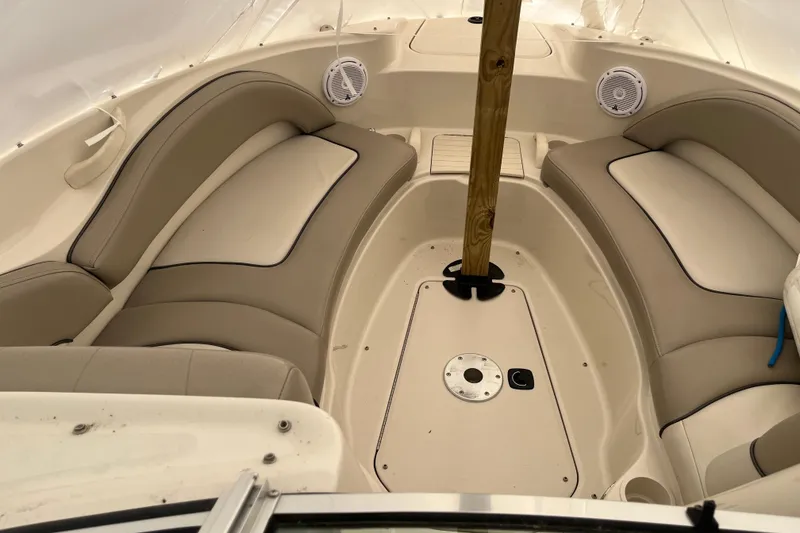 Slide: The Image of 2004 Sea Ray 220 Sundeck interior with beige seating and central pole. - 20