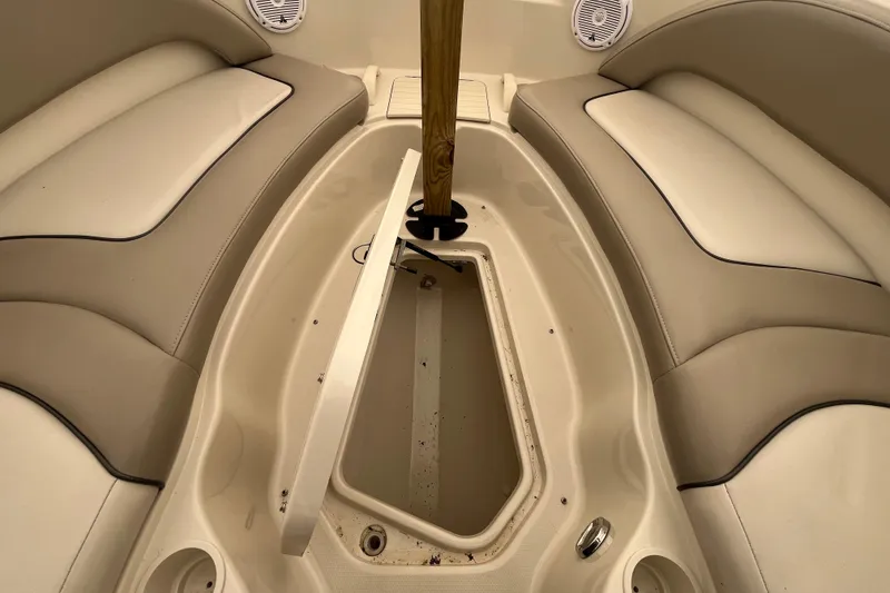 Slide: The Image of 2004 Sea Ray 220 Sundeck interior with open storage compartment and cushioned seating. - 21