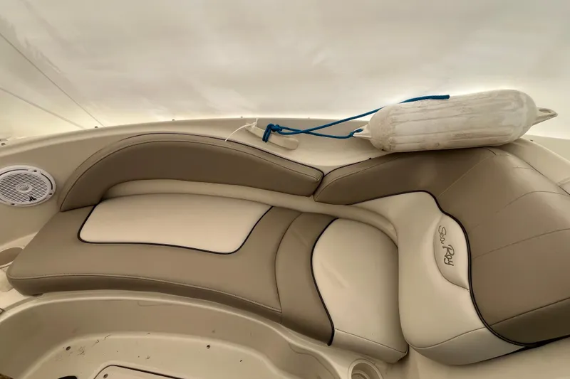 Slide: The Image of 2004 Sea Ray 220 Sundeck interior with beige seating and a white fender. - 24