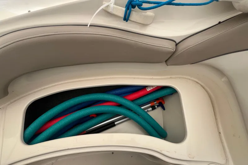 Slide: The Image of Storage compartment on 2004 Sea Ray 220 Sundeck with pool noodles and equipment. - 25