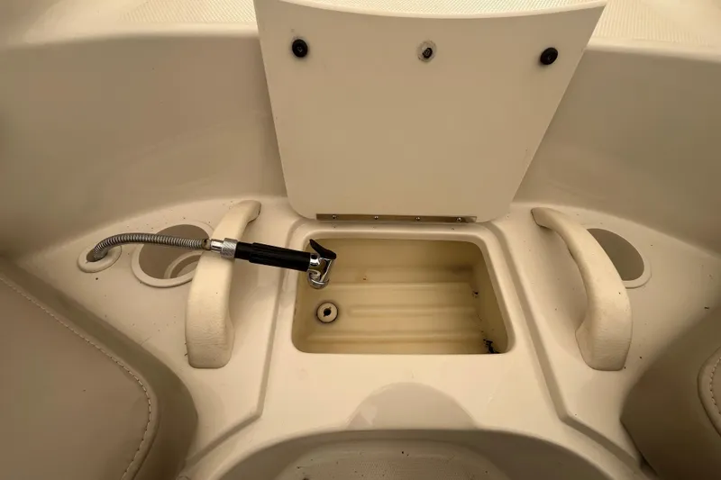 Slide: The Image of 2004 Sea Ray 220 Sundeck boat interior with storage compartment and hose. - 27
