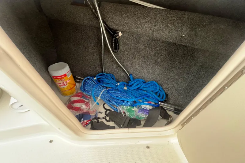 Slide: The Image of Storage compartment in 2004 Sea Ray 220 Sundeck with rope and disinfectant wipes. - 29