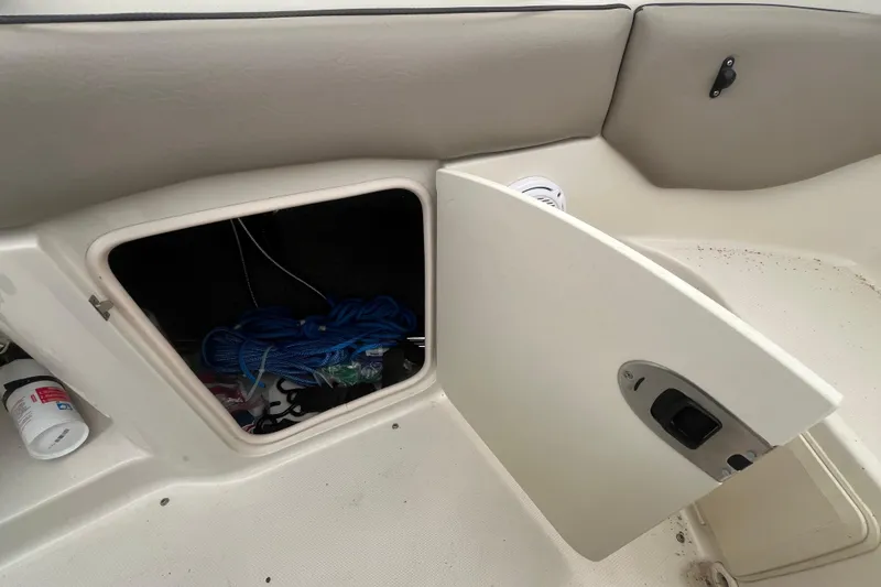 Slide: The Image of Open storage compartment on 2004 Sea Ray 220 Sundeck boat with blue rope inside. - 30