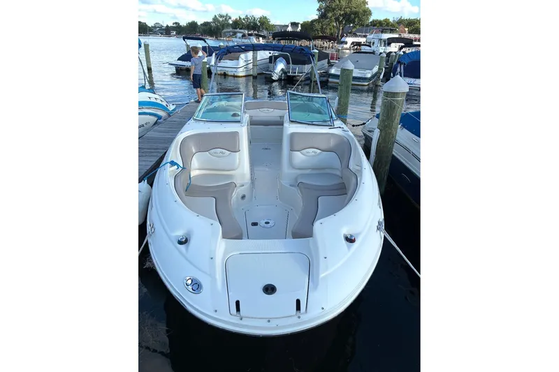 Slide: The Image of 2004 Sea Ray 220 Sundeck boat docked at marina, featuring spacious seating. - 5