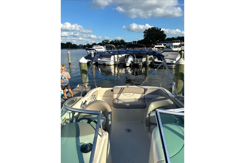 Slide: The Image of 2004 Sea Ray 220 Sundeck boat docked at marina with clear skies. - 6