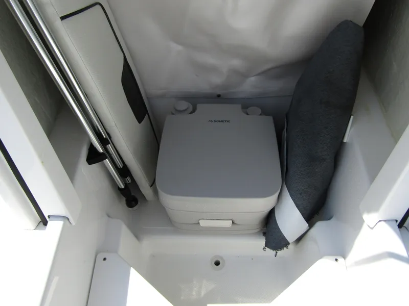 Slide: The Image of 2024 Wellcraft 202 Fisherman boat interior with portable toilet and storage area. - 10